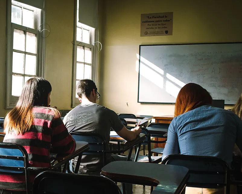 Students in a classroom facing the board